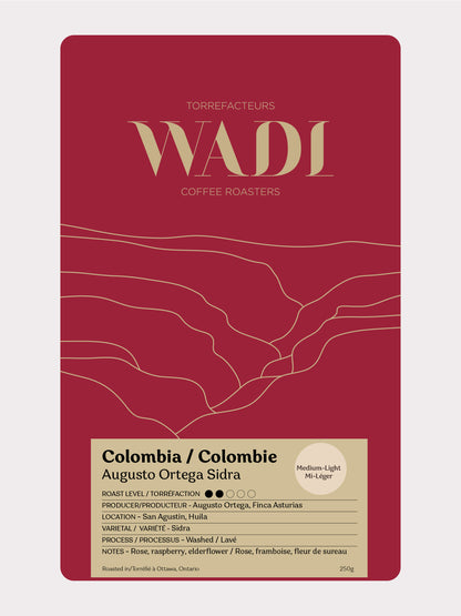 Bag of Colombia Augusto Ortega Sidra coffee from Wadi Coffee Roasters with colorful label and fresh coffee beans.
