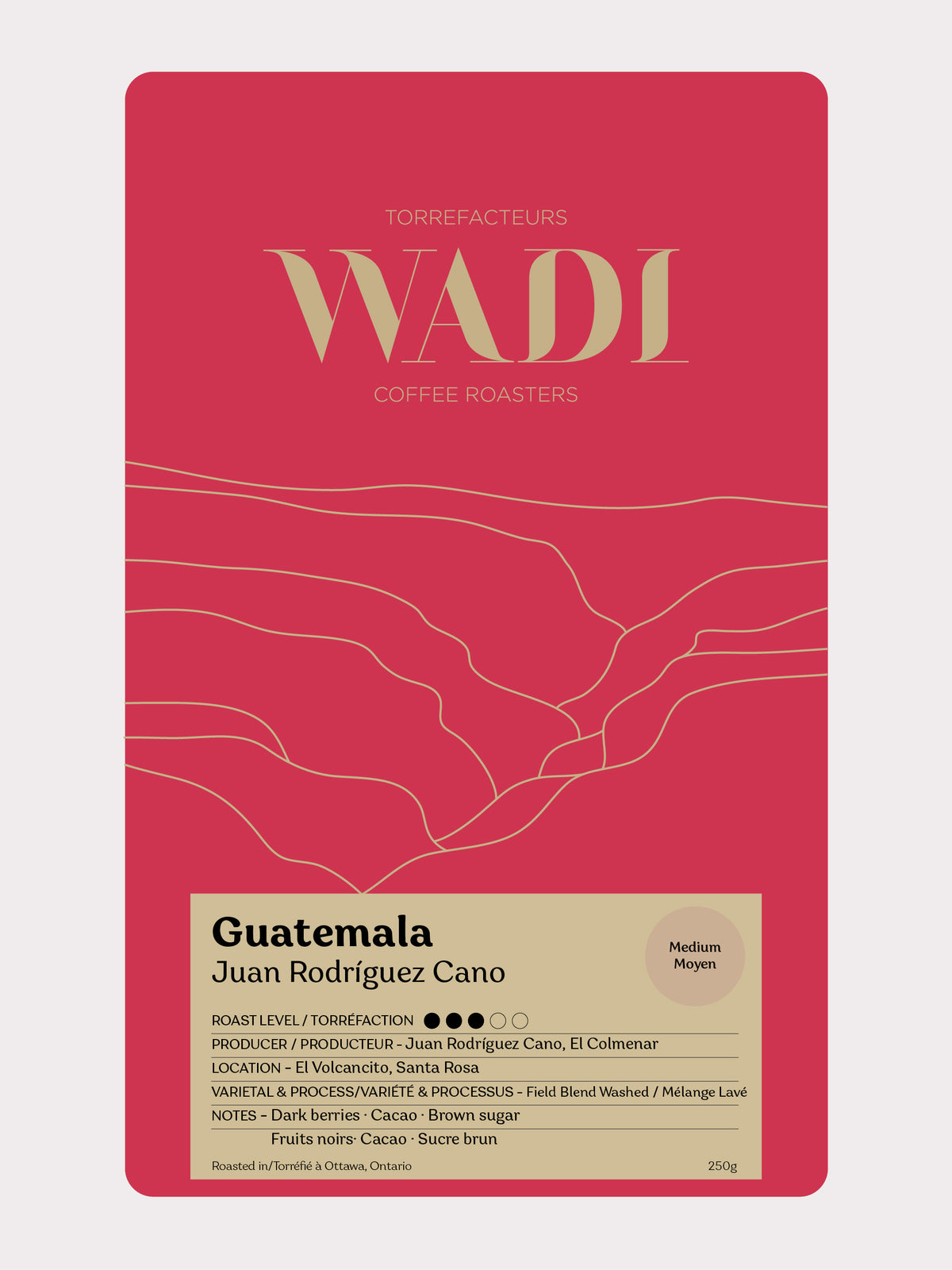 Wadi Coffee Roasters Guatemala El Colmenar coffee bag with vibrant label and rich brown coffee beans in the background.